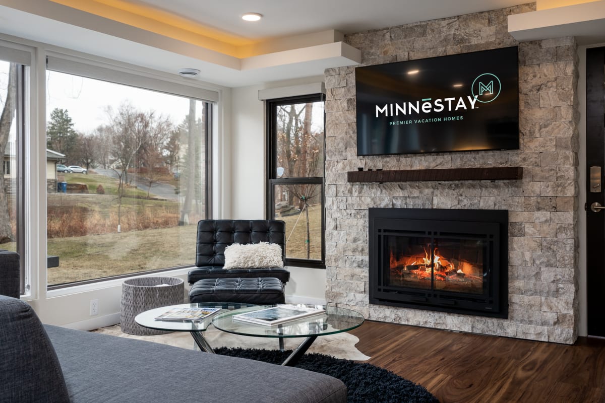 Unwind by the crackling fireplace in your spacious living room, where modern comfort meets elegant stone accents and stunning natural views.