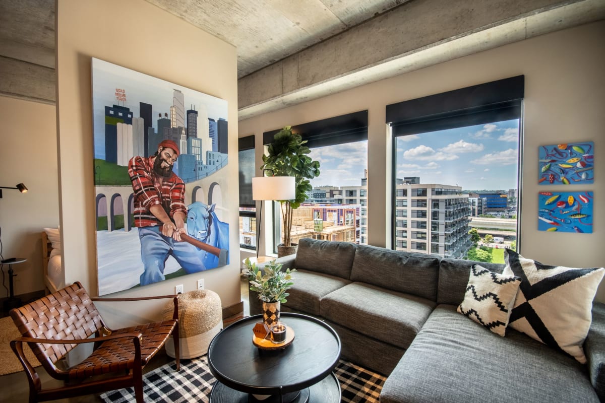 Unwind in your stylish living room with stunning city views through floor-to-ceiling windows and thoughtfully curated artwork creating the perfect urban retreat.