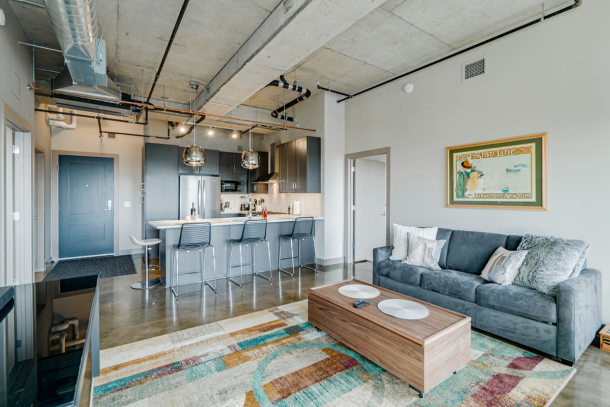 Stylish modern loft with exposed ceiling details, sleek kitchen island, and cozy living area where you'll love unwinding.