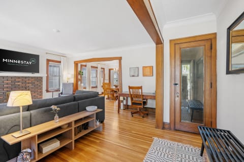 Spacious living room featuring a sectional sofa, wooden furniture, and a dining area with natural light.