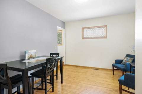 A cozy dining area with a black table, high-backed chairs, and teal seating.