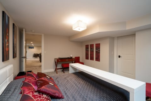 A modern bedroom featuring a white bed, decorative pillows, and artistic wall panels.