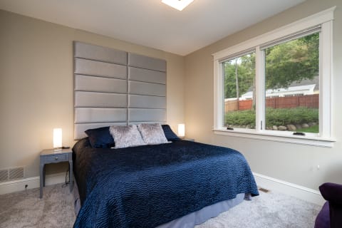 Cozy bedroom with navy blue bedding and stylish furnishings.
