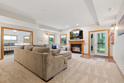 Cozy living room with a sectional sofa, fireplace, and natural light from windows.