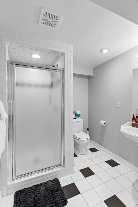 Minimalistic bathroom with shower, toilet, and sink.