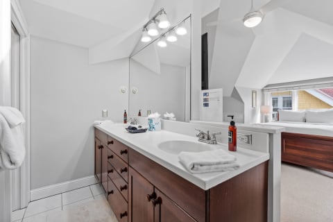 Modern bathroom featuring white and dark wood aesthetics with bright lighting.