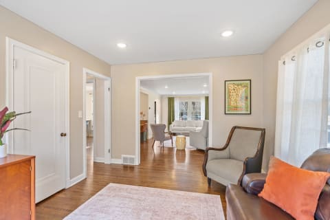 Living room featuring beige walls, hardwood floors, and contemporary furnishings with a decorative map.
