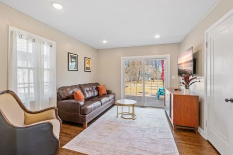 A cozy living room featuring a leather sofa, coffee table, and sliding glass doors.