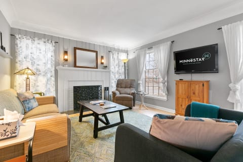 Cozy living room with gray walls, a fireplace, and comfortable seating.