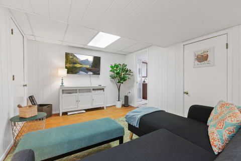 A modern living room featuring a large TV, sectional sofa, and decorative furnishings.