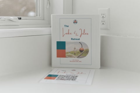 A welcome packet for Lake of the Isles Retreat on a countertop in a bright kitchen.
