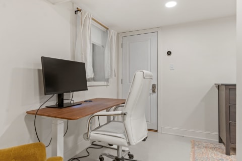 Modern workspace featuring a desk with monitor and an ergonomic chair.