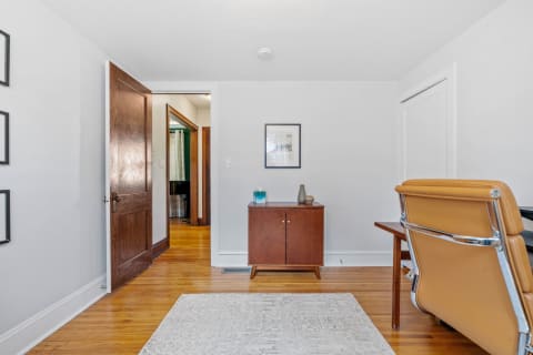 Interior view of a cozy room with a wooden cabinet and leather office chair.