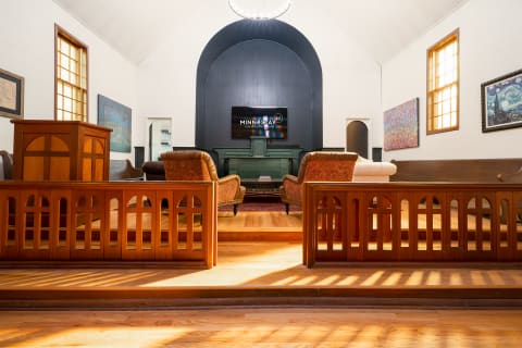 Interior of a room with high ceilings, sofas, and artistic wall decor.