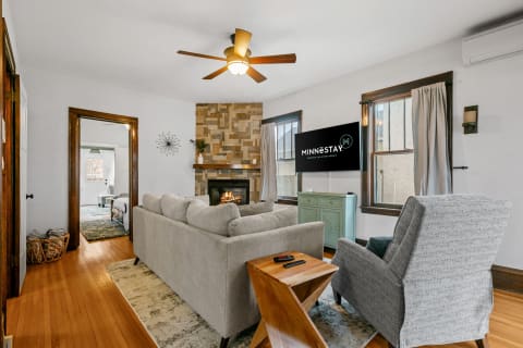 Inviting living room with a gray sectional sofa, stone fireplace, and stylish decor.