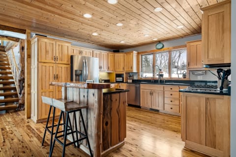 Modern kitchen with wooden cabinets and black countertops.