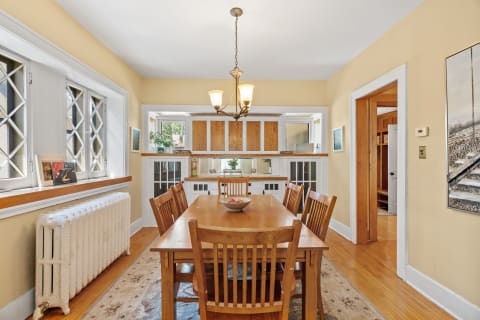 Cozy dining room with a wooden table, chairs, and vintage radiator.