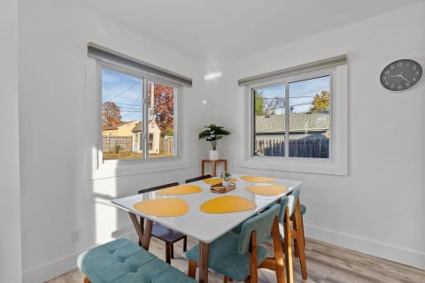 Bright dining nook featuring a white table with yellow placemats and light blue seating.