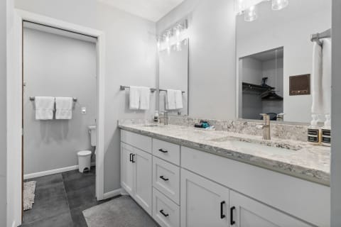 A modern bathroom with a granite countertop vanity and elegant fixtures.