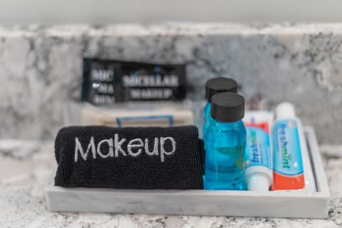 A tray with a black towel labeled 'Makeup' and skincare items including blue bottles and toothpaste.