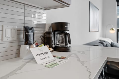 Modern kitchen countertop with a coffee maker, coffee pack, and a thank-you note.