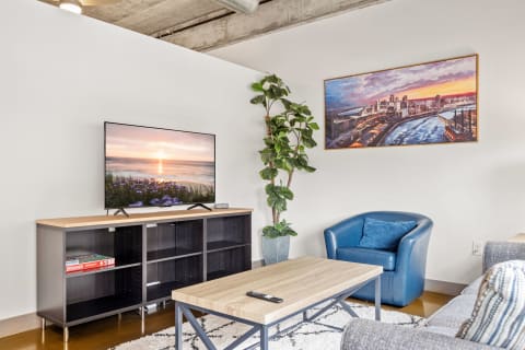 Stylish living room with a flat-screen TV, coffee table, and a blue armchair.