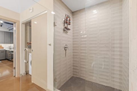 Contemporary bathroom with glass shower and hexagonal tiled floor.