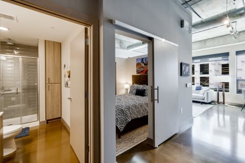 Interior view of a modern apartment featuring a bedroom and bathroom.