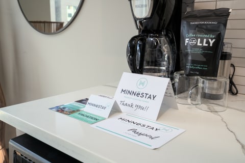 Countertop showcasing MINNēSTAY vacation rental materials and a coffee maker.