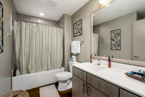 Interior view of a modern bathroom with a tub, sink, and decorative elements.