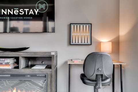 Modern workspace with a small desk, lamp, and artwork in a cozy living area.