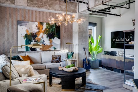 Stylish living room featuring a gray sectional sofa, abstract art, and a decorative coffee table.