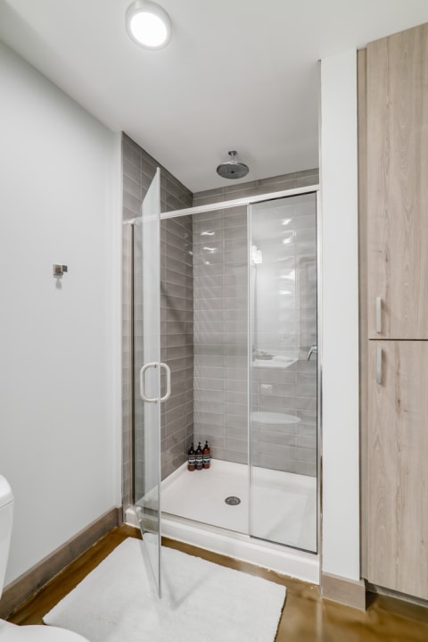 Contemporary bathroom featuring a glass shower and light wood accents.