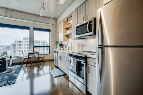Contemporary kitchen featuring stainless steel appliances and large windows