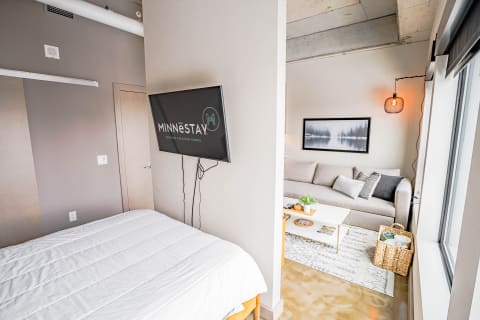 A modern living area showing a bed, a sofa, and a coffee table in an inviting setup.