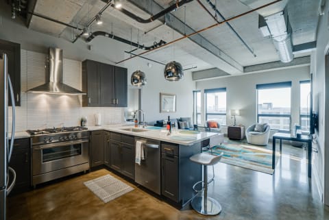 An open-concept kitchen and living area featuring a modern aesthetic with industrial design.