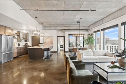 Stylish modern apartment interior with open kitchen and living space and large windows.