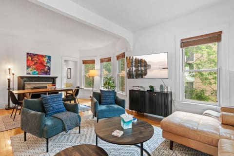 Cozy living room featuring modern furniture, a large TV, and vibrant artwork.