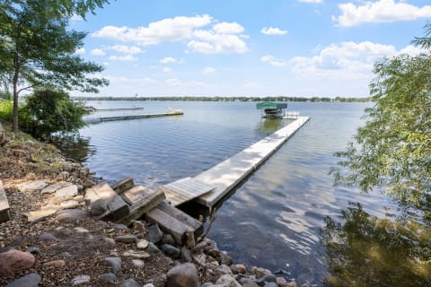 Lake view with a wooden dock and green canopy boat.