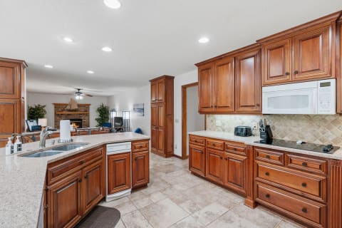 A well-designed kitchen featuring wooden cabinets, granite countertops, and modern appliances.