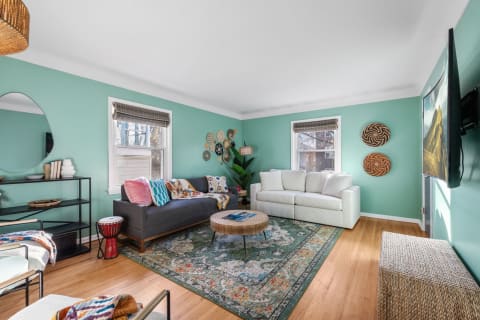 Cozy living room with mint green walls and colorful decorative elements.