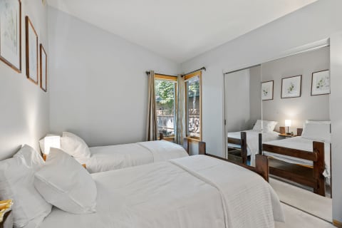 Interior view of a bedroom featuring twin beds and botanical decor.