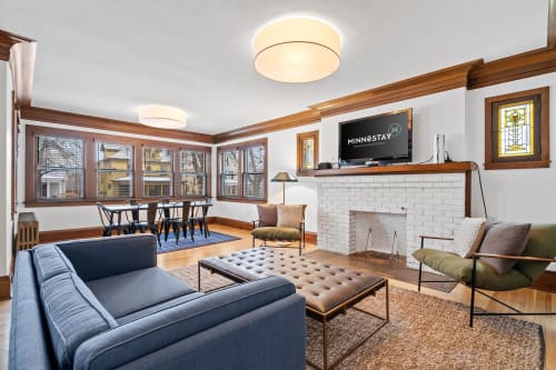 Relax in your stylish living room featuring rich wood trim, cozy fireplace, and comfortable seating perfect for unwinding after exploring.