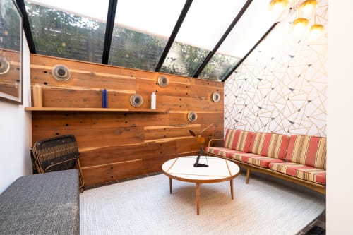 Unwind in your bright sunroom where mid-century charm meets modern comfort beneath soaring glass ceilings that flood the space with natural light.