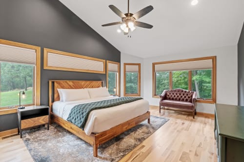 Your serene bedroom sanctuary awaits with stunning forest views through expansive windows, creating a peaceful retreat.