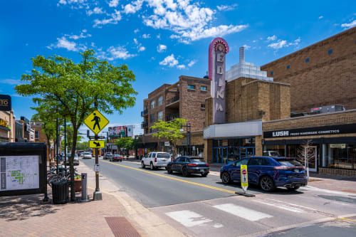 A vibrant downtown street scene featuring historic brick buildings, local shops, and the iconic cinema theater in the heart of the area.