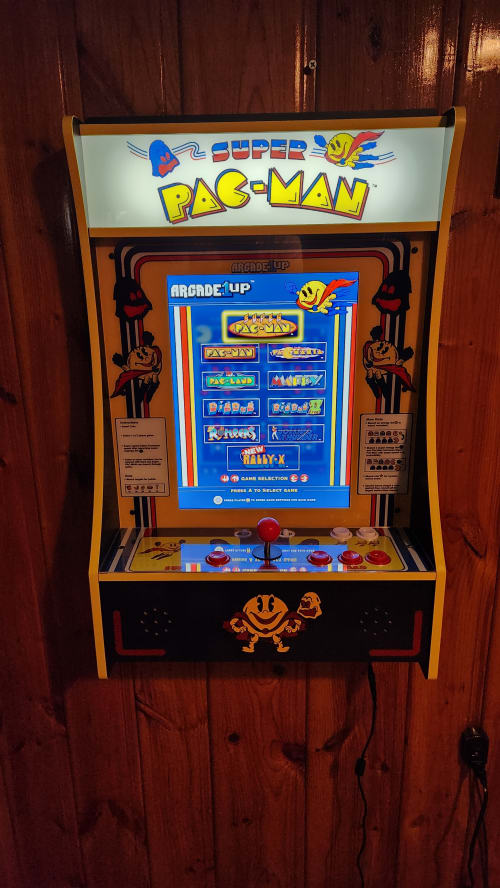 Challenge friends to classic Pac-Man in this vintage arcade cabinet, bringing nostalgic gaming fun to your mountain getaway.