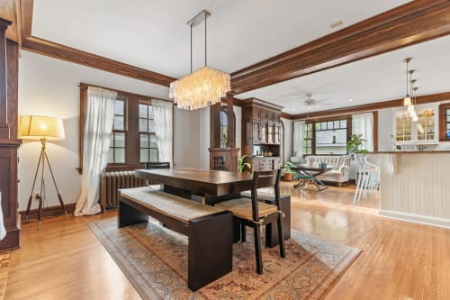 Gather around your elegant dining table beneath the stunning chandelier, where rich wood beams and gleaming hardwood floors create the perfect setting for memorable meals.