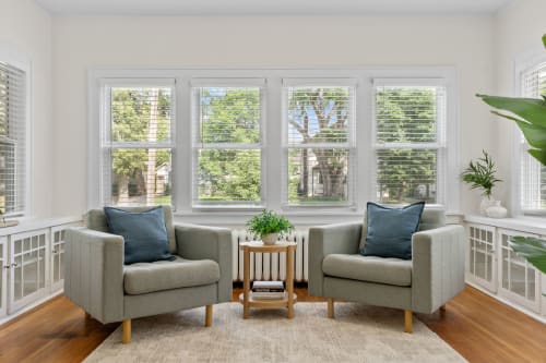 Settle into your bright reading nook with twin armchairs and garden views through expansive windows.