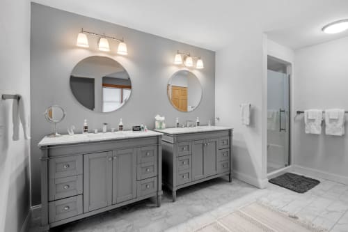 Your spacious bathroom features dual vanities with elegant lighting and marble countertops, perfect for your morning routine.